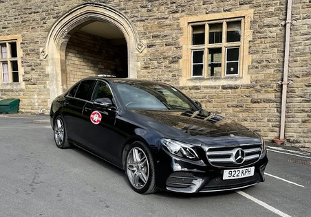 Alpha’s black taxi photographed outside a stone building